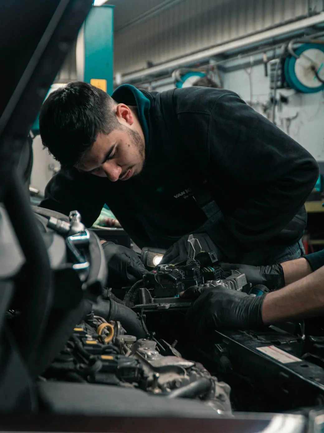 A technician working on a car engine in the workshop